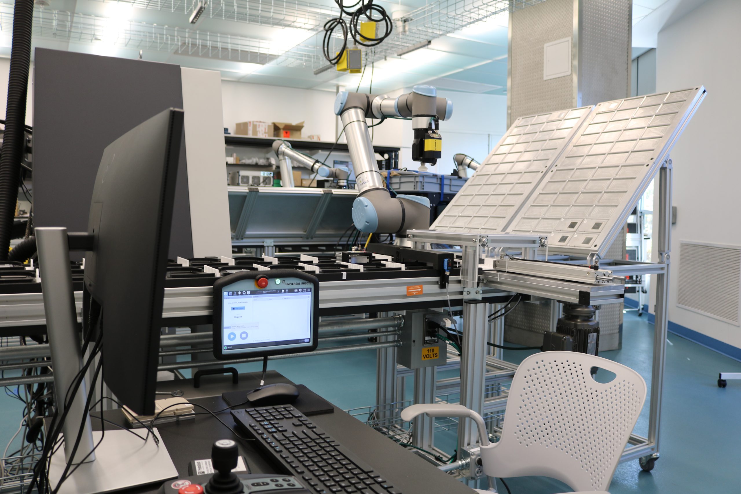 infeed/outfeed station with robotic arm and control panel