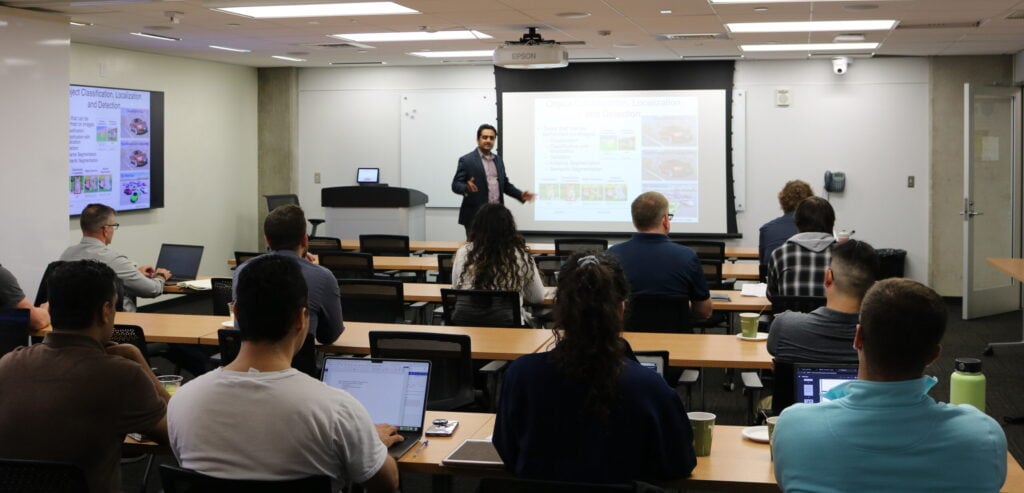 Professor giving lecture to class in front of projector