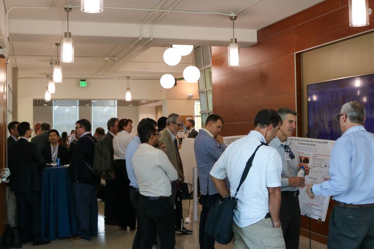 A lobby full of people looking at research posters and talking to each other.