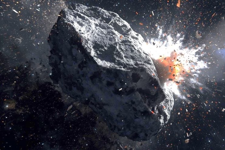 an asteroid mid-impact spews ejecta into space